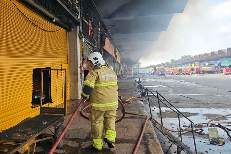 Rio de Janeiro (RJ), 03/12/2025 - Soldado do Corpo de Bombeiro joga água para conter incêndio em galpão da Ceasa. Foto: CBEMRJ/Divulgação