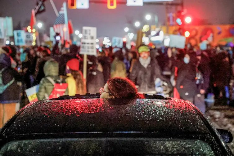 A person looks through a vehicle’s sunroof as people protest against increased immigration enforcement, a day after a U.S. Immigration and Customs Enforcement (ICE) agent fatally shot Renee Nicole Good, in Minneapolis, Minnesota, U.S., January 8, 2026. REUTERS/Brian Snyder     TPX IMAGES OF THE DAY